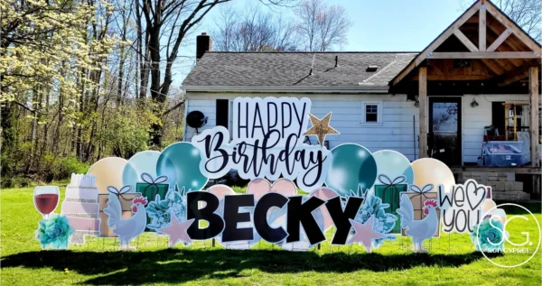 A yard sign in front of house that says "Happy Birthday Becky" in black letters. Colorful graphics surround the sign.